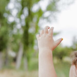 Main d’un bébé levée pour illustrer l’usage des signes dans la communication gestuelle préverbale.