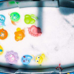 Bac rempli d'eau avec des objets flottants colorés, prêt pour l'atelier Messy Play.