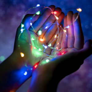 main d'enfant tenant une guirlande lumineuse dans le cadre d'un atelier snoezelen