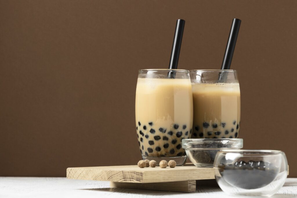 Verre avec des perles de tapioca et du jus pour en faire un bulbe tea, avec une paille à l'intérieur des 2 verres.
