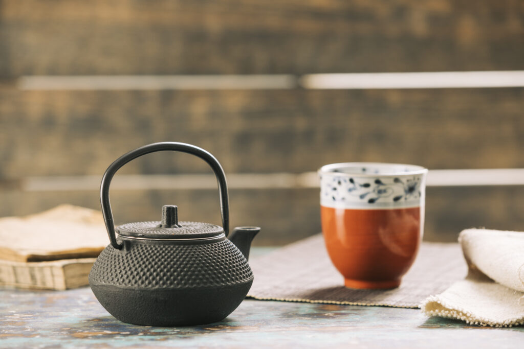 Théière et tasse coréenne posées sur une table à l'extérieur.