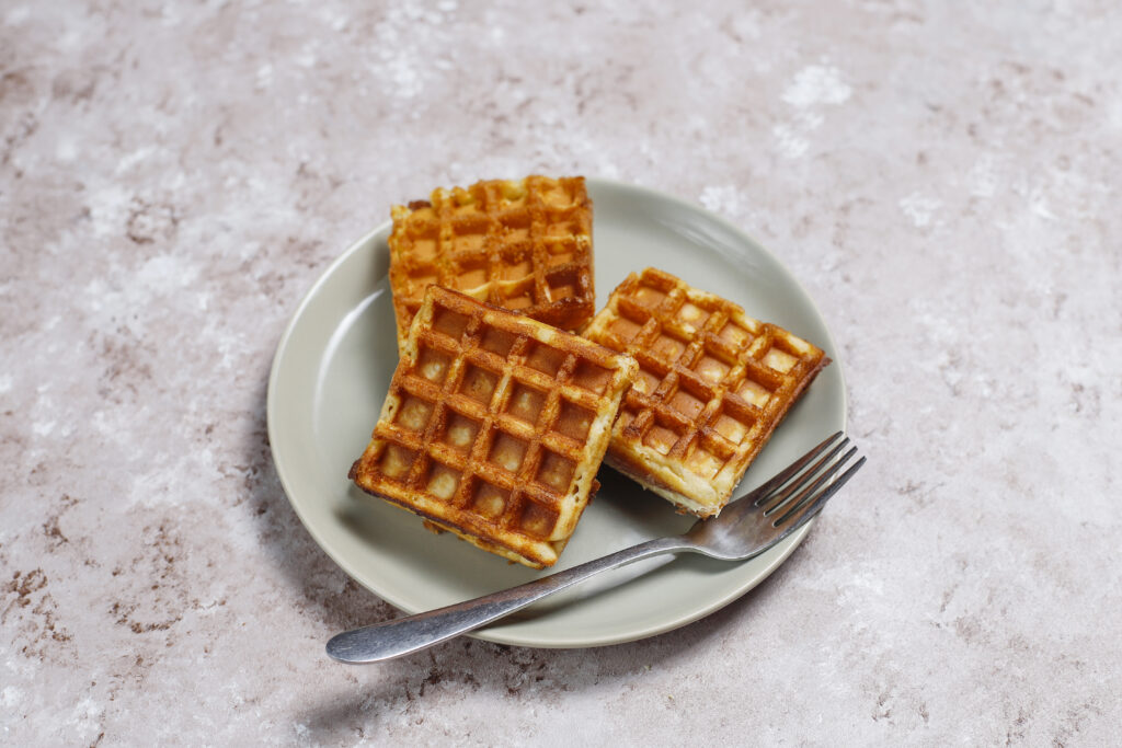 3 gauffres posés dans une assiettes avec une fourchette