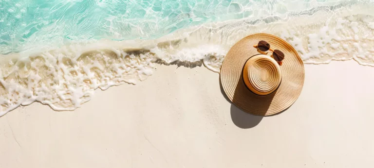Chapeau de plage sur le sable pour illustrer le carnet d’évasion Casa Boho