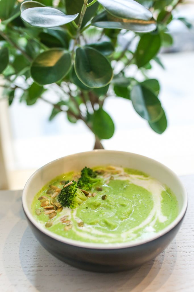 Delicious creamy broccoli soup garnished with seeds, a healthy meal option.