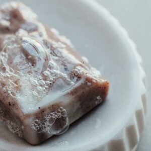 Photo par freestocks.org Detailed close-up of a handmade organic soap bar with bubbles on a dish, highlighting its texture.