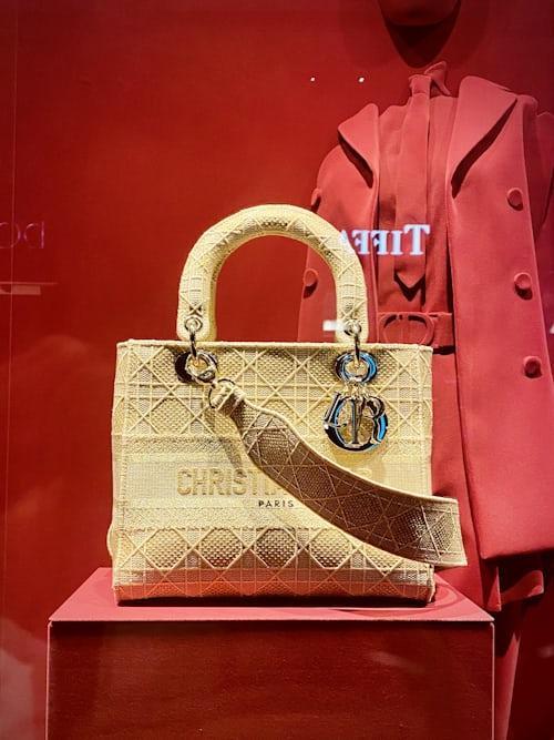 sac à main couleur or de la marque Christian Dior dans une vitrine de magasin
