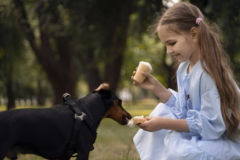 Une fille donne un morceau de glace à son chien.